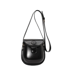 Glossy black saddle bag with U-shaped design and adjustable shoulder strap for women