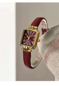 Macro di un orologio vintage quadrato con cinturino in pelle rossa e cassa dorata