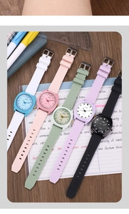 Flat lay of colorful minimalist quartz watches with silicone straps on a wooden desk