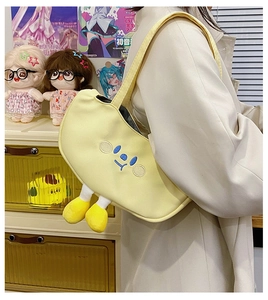 Close-up of cute yellow canvas crossbody bag featuring 3D plush doll legs and embroidery