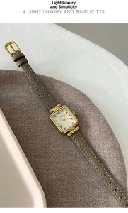 Dettaglio dell'orologio rettangolare dorato con quadrante romano e cinturino in pelle