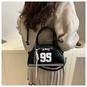 Detail of a black patent leather crossbody bag with white Los Angeles 95 print