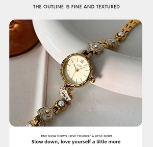 Détail du bracelet GEDI avec maillons floraux dorés et ornements en perles blanches