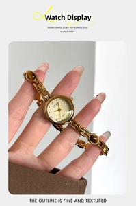 Close-up of gold chain watch band with amber stone accents and small vintage dial