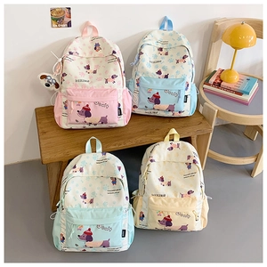 Detail of cute cartoon dog printed backpacks in multiple pastel colors for students
