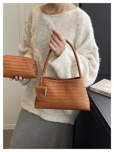 Detail of woven texture on brown shoulder bag and matching clutch set worn by model