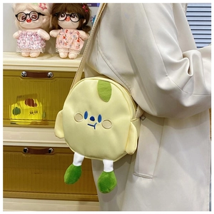 Detail of yellow round canvas bag with cartoon face embroidery and green plush feet