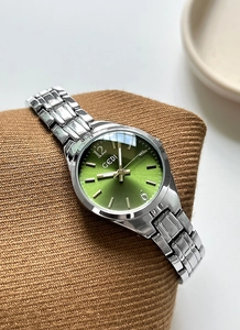 Detailed macro view of GEDI silver watch with a sunburst green dial and metal chain