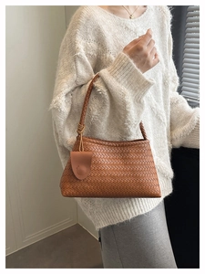 Detailed weave pattern on brown woven shoulder bag with a small matching pouch pendant