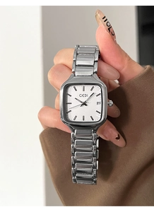 Gros plan détaillé d'une montre à quartz carrée argentée avec dateur et bracelet en métal