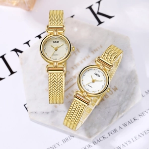 Elegant gold quartz watches for women with Milanese mesh band on marble display stands