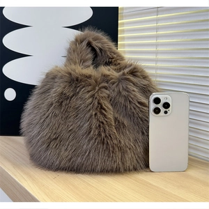 Gros plan d'un sac à main en fausse fourrure marron avec un smartphone pour l'échelle