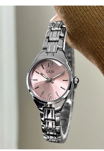 Detailed macro of a silver quartz watch featuring a pink sunburst dial and steel strap