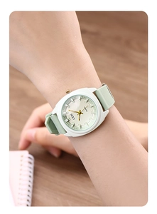 Close-up of minimalist GEDI watch with light green silicone strap on a female wrist