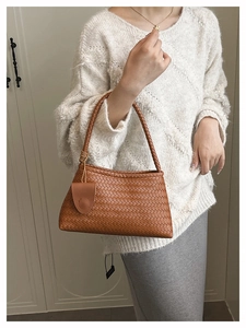Brown woven leather hobo bag styled with a white sweater for an elegant commute look