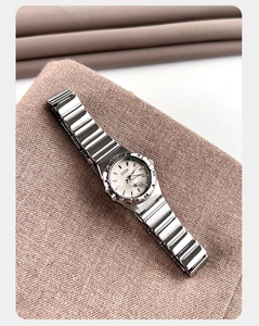 Primer plano detallado de un reloj de cuarzo plateado con esfera blanca brillante