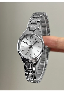 Macro shot of silver quartz watch with round dial and polished link bracelet