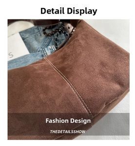 Detail of brown suede tote bag featuring white contrast stitching and woven strap accent