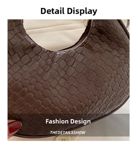 Close-up of brown woven texture on crescent shoulder bag with metallic zipper detail
