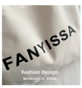 Detailed close-up of white canvas tote bag featuring black FANYISSA letter printing