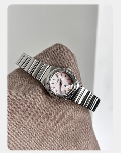Detalle de esfera en nácar rosa y correa de metal bicolor en reloj de lujo para mujer