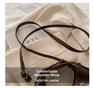 Detail of dark brown woven shoulder bag strap with adjustable metal buckle on a blazer