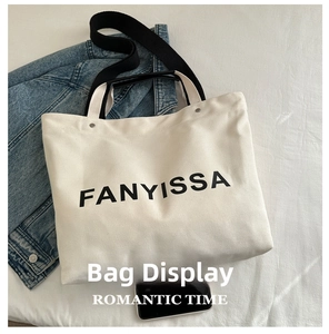 Detail view of large canvas tote bag with FANYISSA logo and dual-purpose black straps