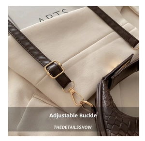 Close-up of golden metal buckle and brown crocodile texture on woven handbag strap