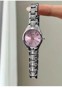 Macro shot of silver quartz watch with a sunray pink dial and metal chain strap