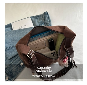 Top view of spacious interior of dark brown suede tote bag with daily essentials