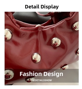 Macro shot of glossy red patent leather bag featuring large silver metal stud details