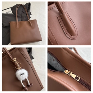 Close-up of brown pebbled leather tote bag with gold zipper and plush monster charm