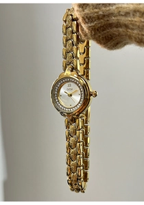 Detailed macro view of luxury gold-tone watch bezel with sparkling rhinestone crystals