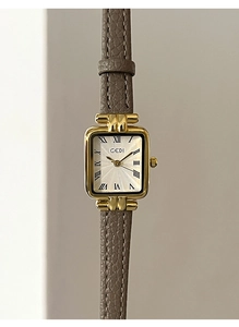 Primo piano di un orologio al quarzo quadrato in oro con quadrante bianco e cinturino grigio