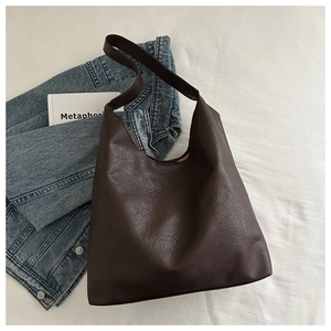 Detailed view of the dark brown hobo tote bag with a fine lychee grain texture surface