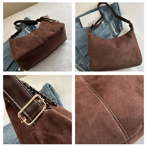 Detail of vintage brown suede shoulder bag with contrast white stitching and gold hardware