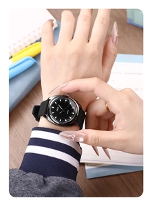 Close-up of minimalist quartz watch with black dial and silicone strap on a female wrist