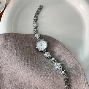 Montre quartz femme élégante avec bracelet chaîne camélia, cadran argenté et perles