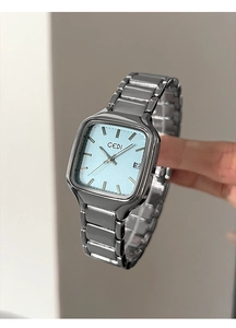Détail de montre à quartz argentée avec cadran rectangulaire bleu clair et dateur