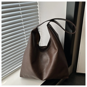 Détail du grand sac cabas marron foncé montrant la texture du cuir et le style vintage