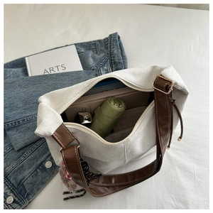 Detail of spacious interior and textured fabric on white tote bag with brown straps