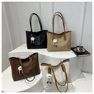 Four minimalist faux leather tote bags in neutral colors with cute fuzzy eye charms