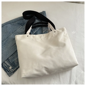 Detail view of large canvas tote bag with contrast dual straps and metal rivets