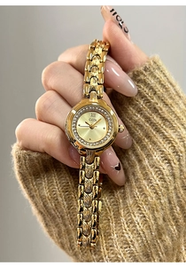 Close-up of gold quartz watch featuring a rhinestone bezel and textured link bracelet