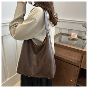 Detail of dark brown vintage faux leather hobo bag with textured finish and wide strap