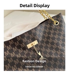 Close-up of brown monogram tote bag with gold chain strap and deer pendant detail