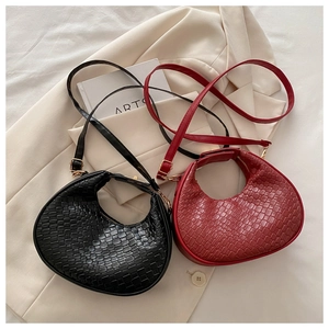 Détail de sacs hobo en cuir tressé noir et rouge montrant texture et sangles