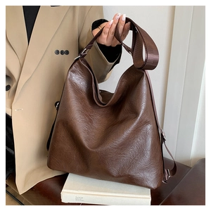 Detailed macro view of the vintage brown PU leather texture on the large tote bag