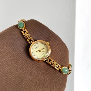 GEDI luxury women gold quartz watch with green emerald-like gemstones on chain strap