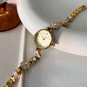 Montre Gedi pour femme avec chaîne florale dorée, perles et cadran rond épuré